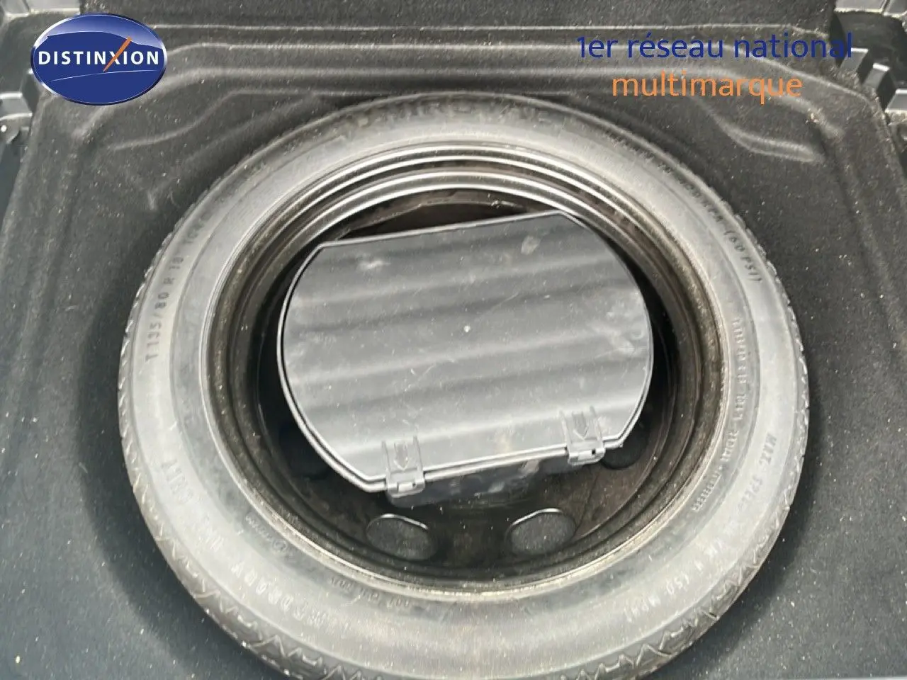 Roue de secours installée dans le coffre d’un Citroën C5 Aircross gris clair, vue de dessus.
