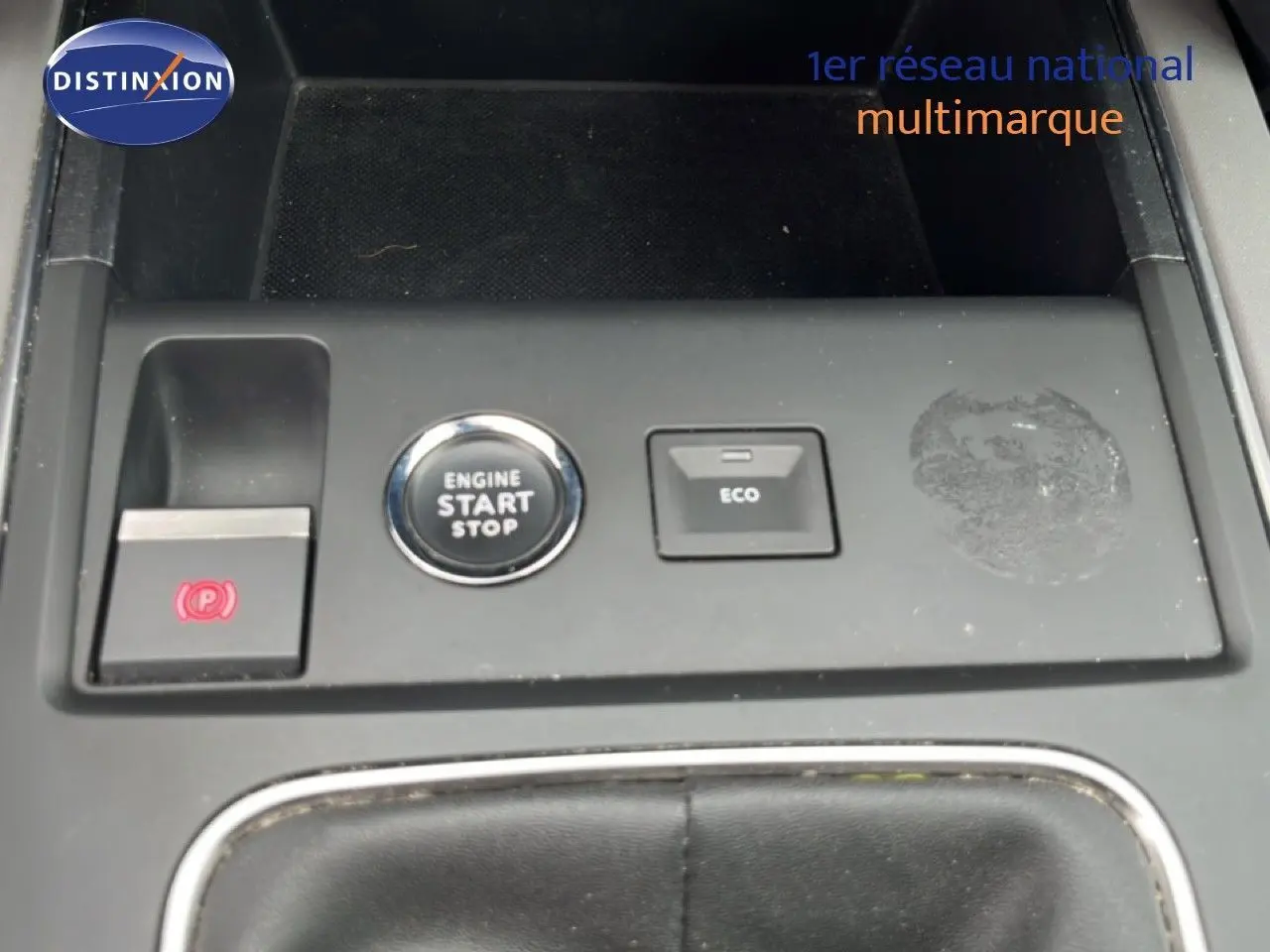 Gros plan sur la console centrale du Citroën C5 Aircross gris clair, montrant les boutons Start/Stop, Eco et frein à main électrique.