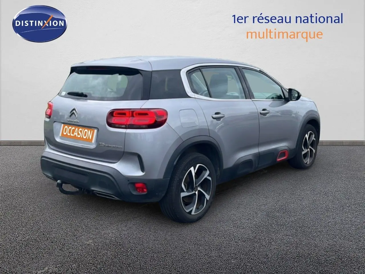 Vue 3/4 arrière droite d'un Citroën C5 Aircross gris clair métal avec feux arrière LED et jantes alliage distinctives.