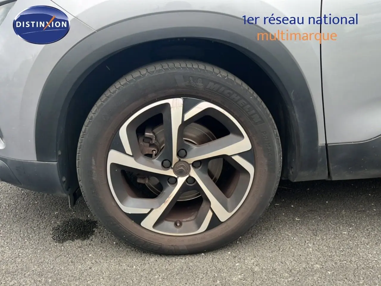 Gros plan sur la roue avant droite d’un Citroën C5 Aircross gris clair métal, avec jante alliage distinctive.