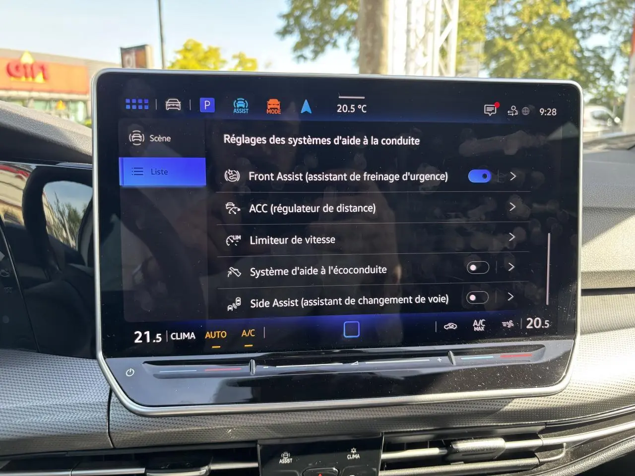 Écran tactile central affichant les réglages d’aide à la conduite dans une Volkswagen Golf blanche, vue intérieure.
