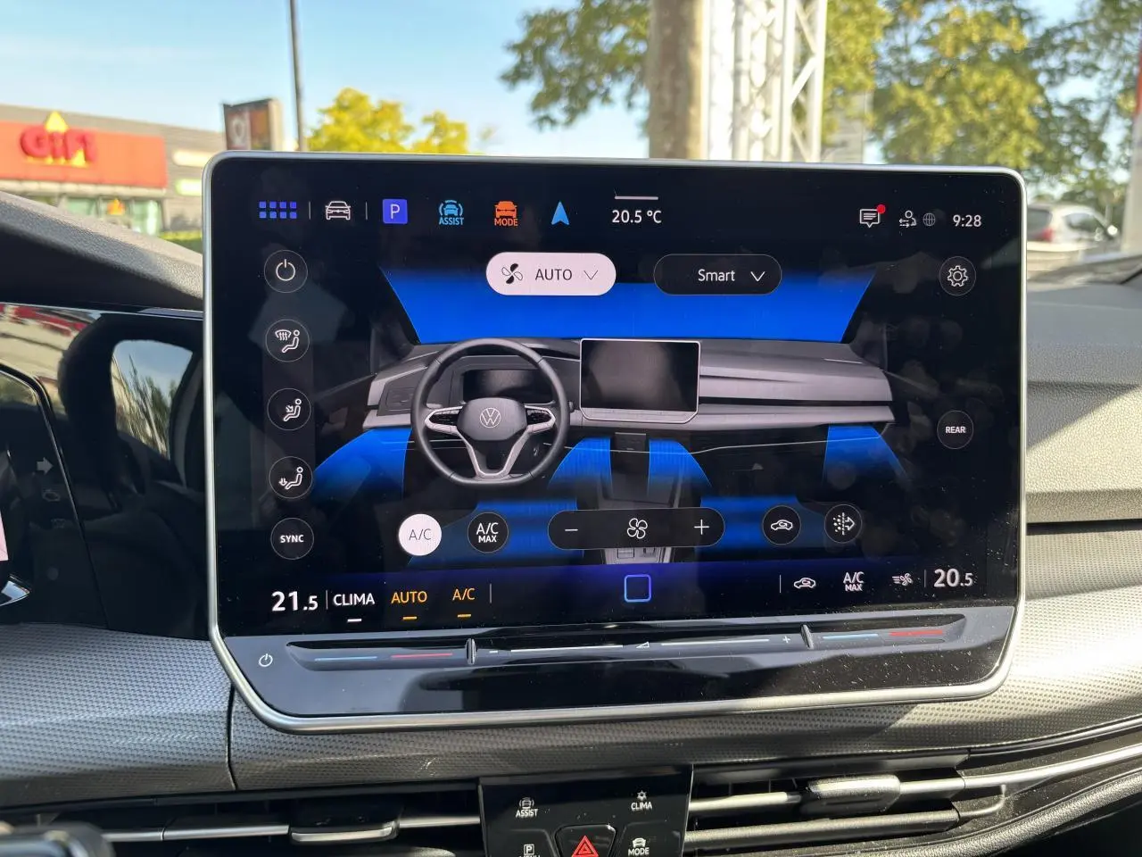 Écran tactile central affichant la commande de climatisation dans l’habitacle d’une Volkswagen Golf blanche 2024.