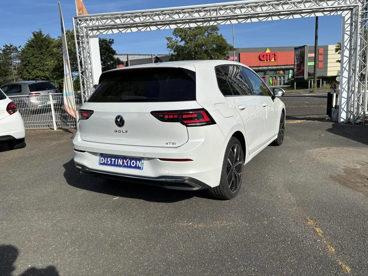 Vue 3/4 arrière droite d'une Volkswagen Golf blanche avec feux arrière LED et jantes alliage 18 pouces.