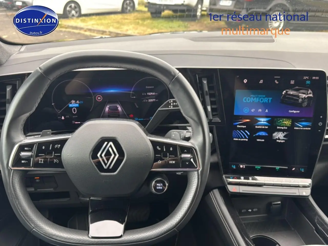 Vue intérieure centrée sur le volant cuir et l’écran tactile du tableau de bord du Renault Austral gris schiste 2024.