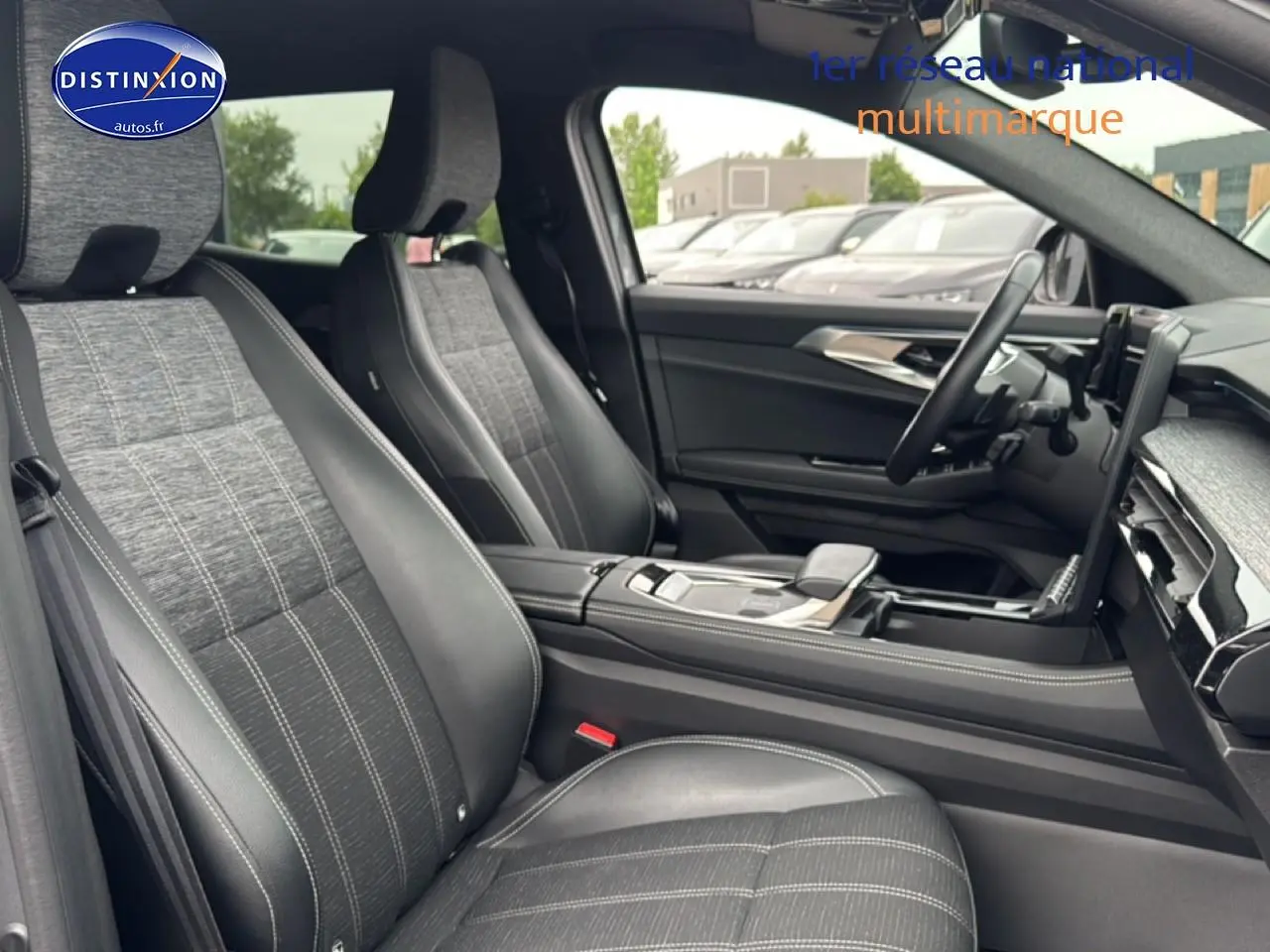 Vue intérieure côté conducteur du Renault Austral 2024, sièges tissu et cuir gris avec console centrale moderne.