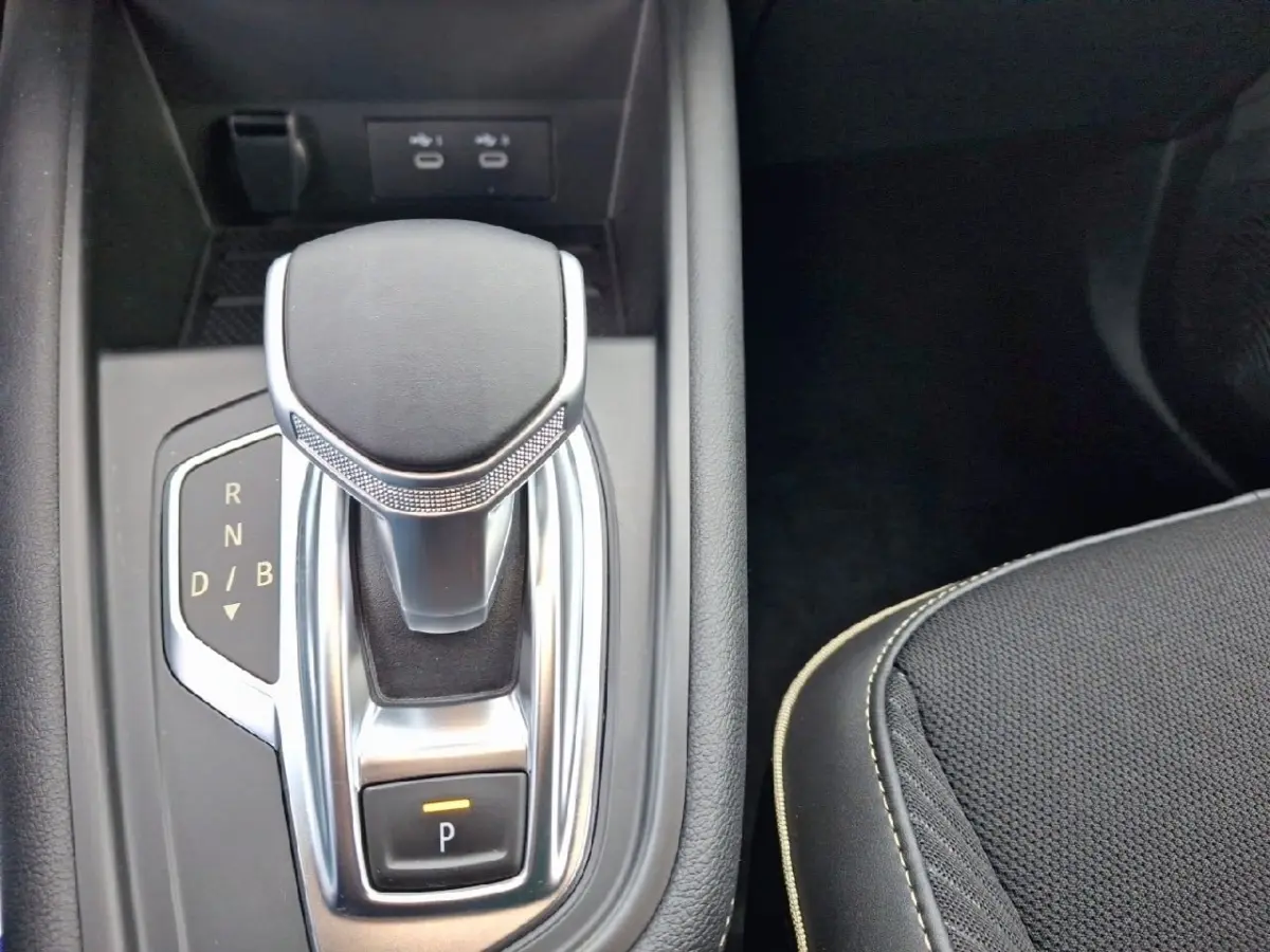 Gros plan sur la commande de boîte automatique noire et argentée du Renault Symbioz Iconic E-Tech 145, côté droit du siège.