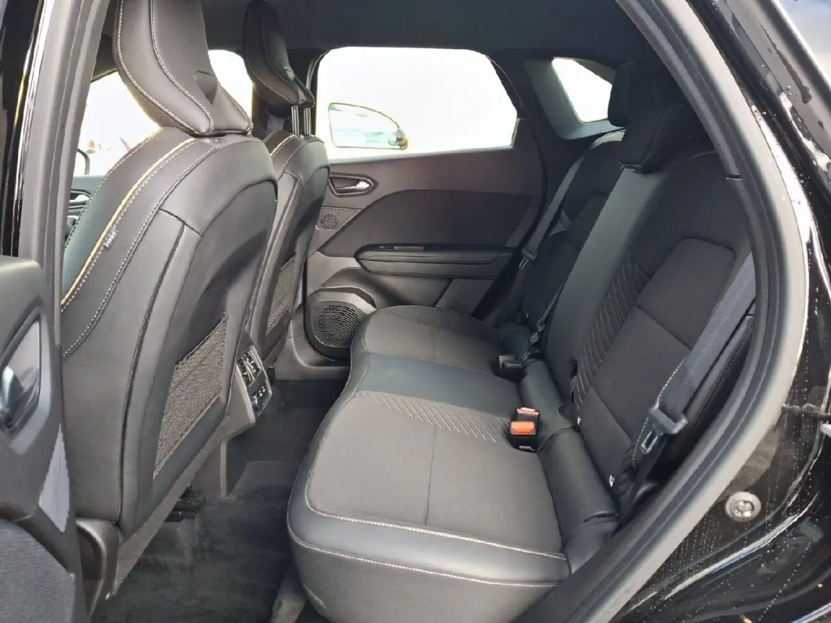 Vue intérieure arrière côté droit du Renault Symbioz noir, montrant les sièges arrière en tissu et cuir avec surpiqûres contrastantes.