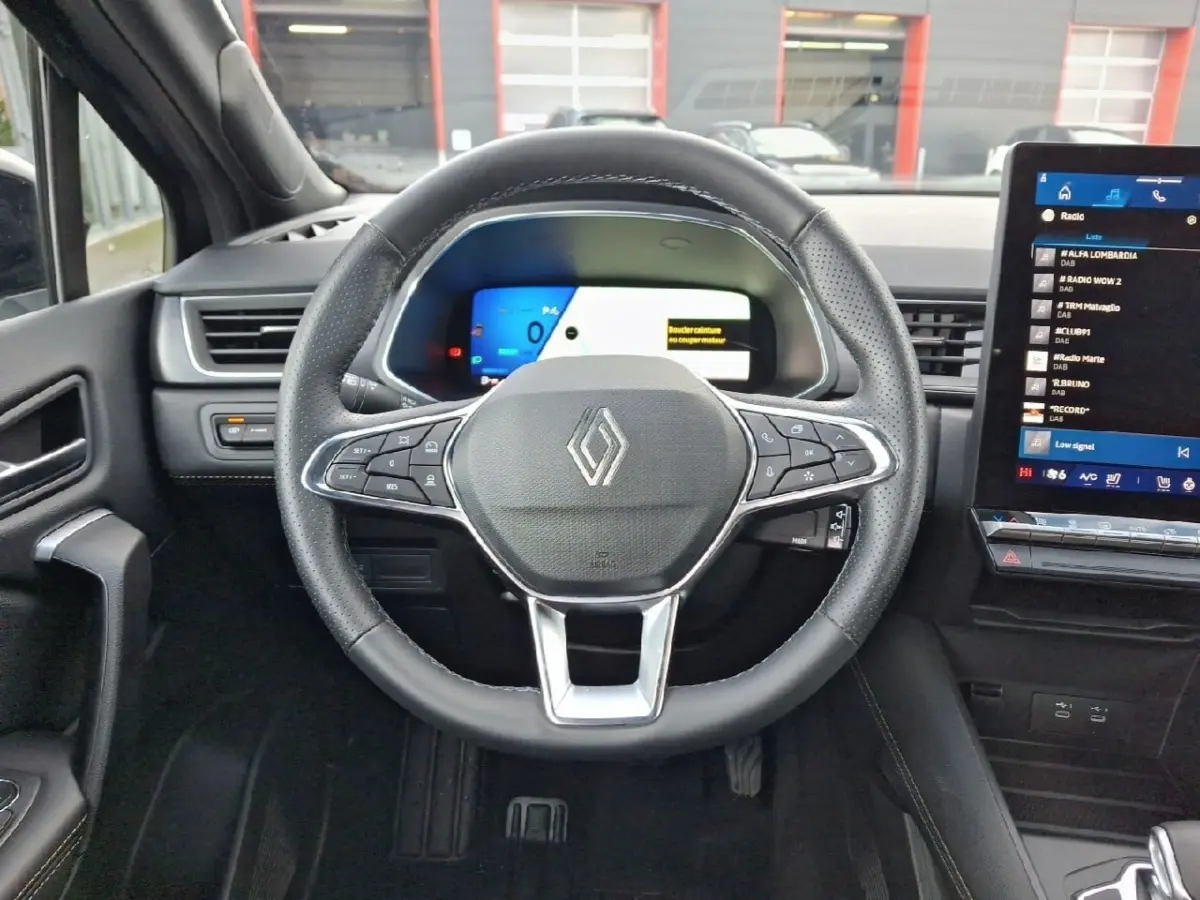 Vue frontale du volant noir de la Renault SYMBIOZ 2025 avec tableau de bord digital et écran tactile central.