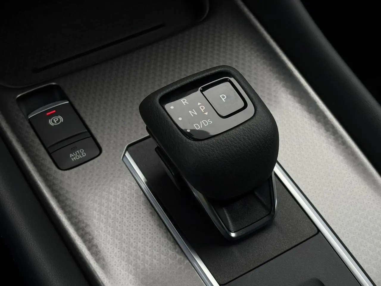 Gros plan sur le levier de vitesses automatique noir et les commandes de frein électrique du Nissan Qashqai 2024.
