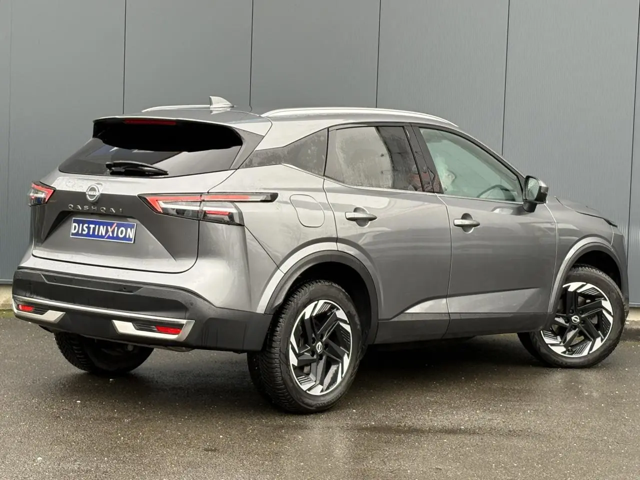 Vue 3/4 arrière droit du Nissan Qashqai 2024 gris Squale avec hayon électrique et jantes alliage 18 pouces.