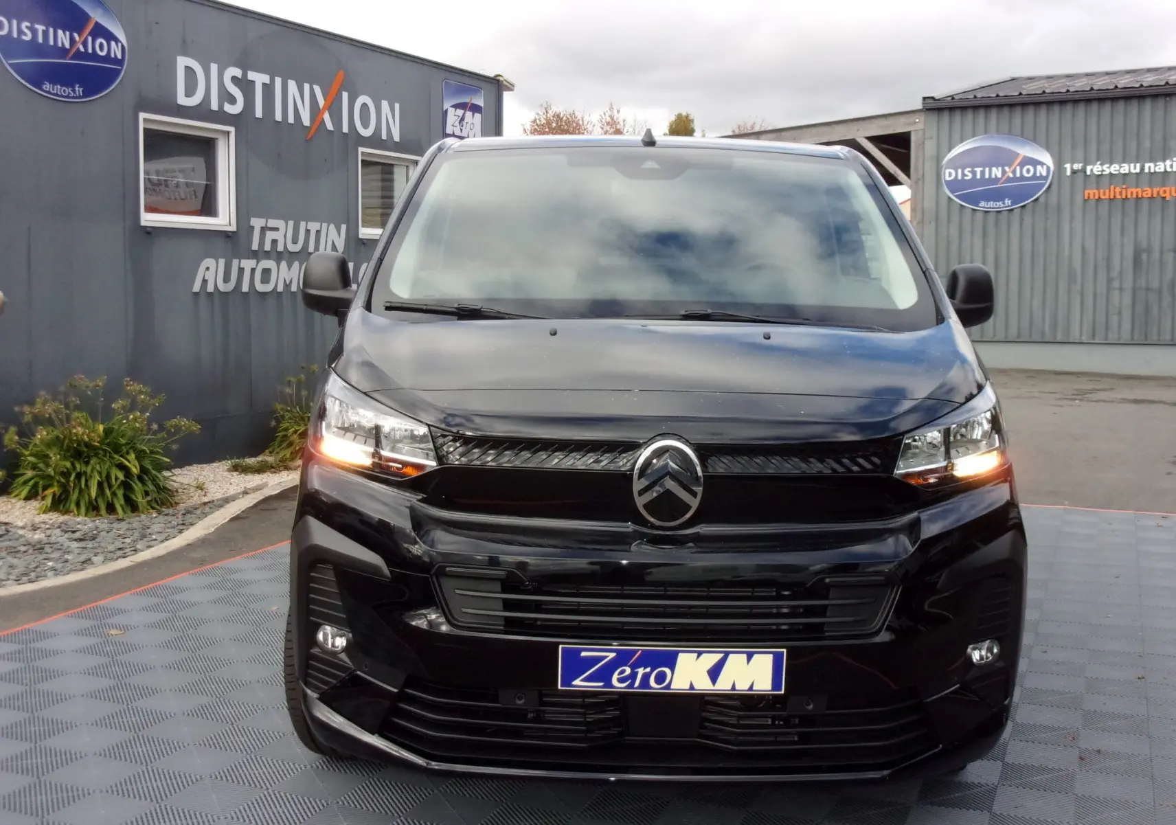 Vue frontale d’un Citroën Jumpy Cabine Approfondie noir Perla avec feux allumés et plaque « Zéro KM » visible.