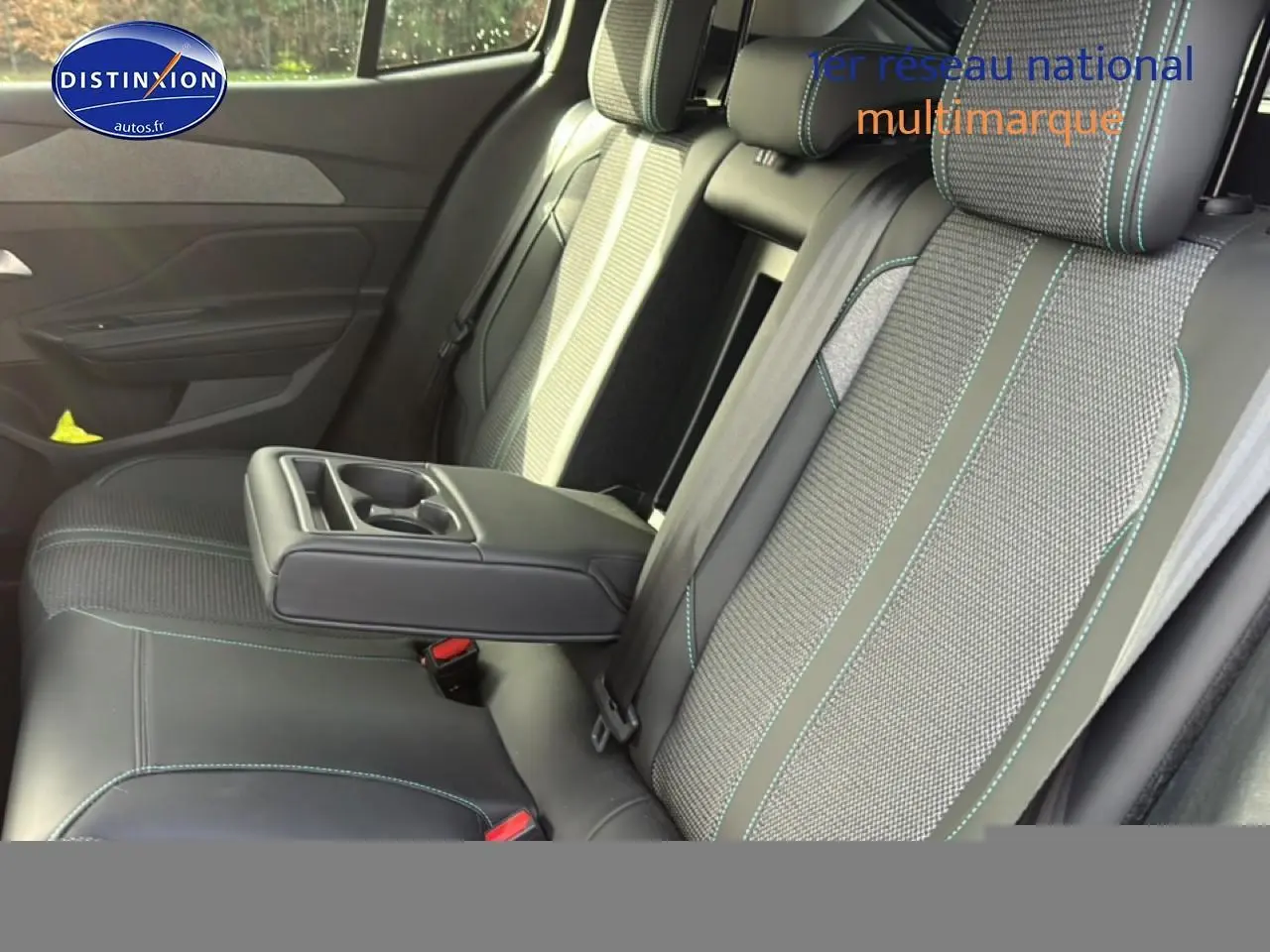 Vue intérieure des sièges arrière de la Peugeot 408 Hybrid 145 allure, avec accoudoir central et sellerie bicolore.