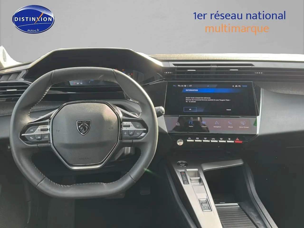 Vue intérieure centrée sur le volant cuir et l'écran tactile du tableau de bord de la Peugeot 408 Hybrid 145 gris sélénite.