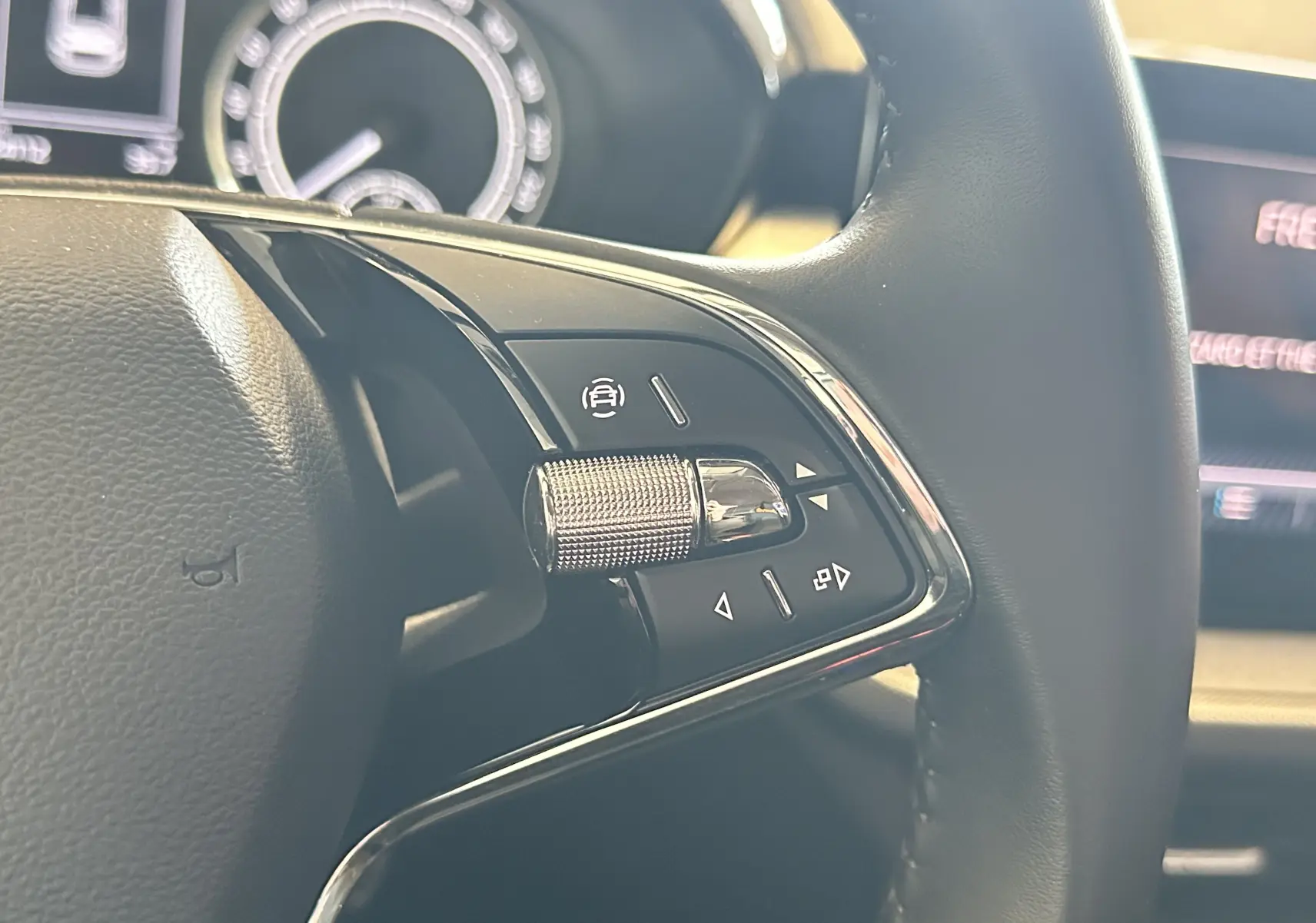 Gros plan sur les commandes multifonctions à droite du volant noir du Skoda Fabia Ambition 2023, avec molette métallique.