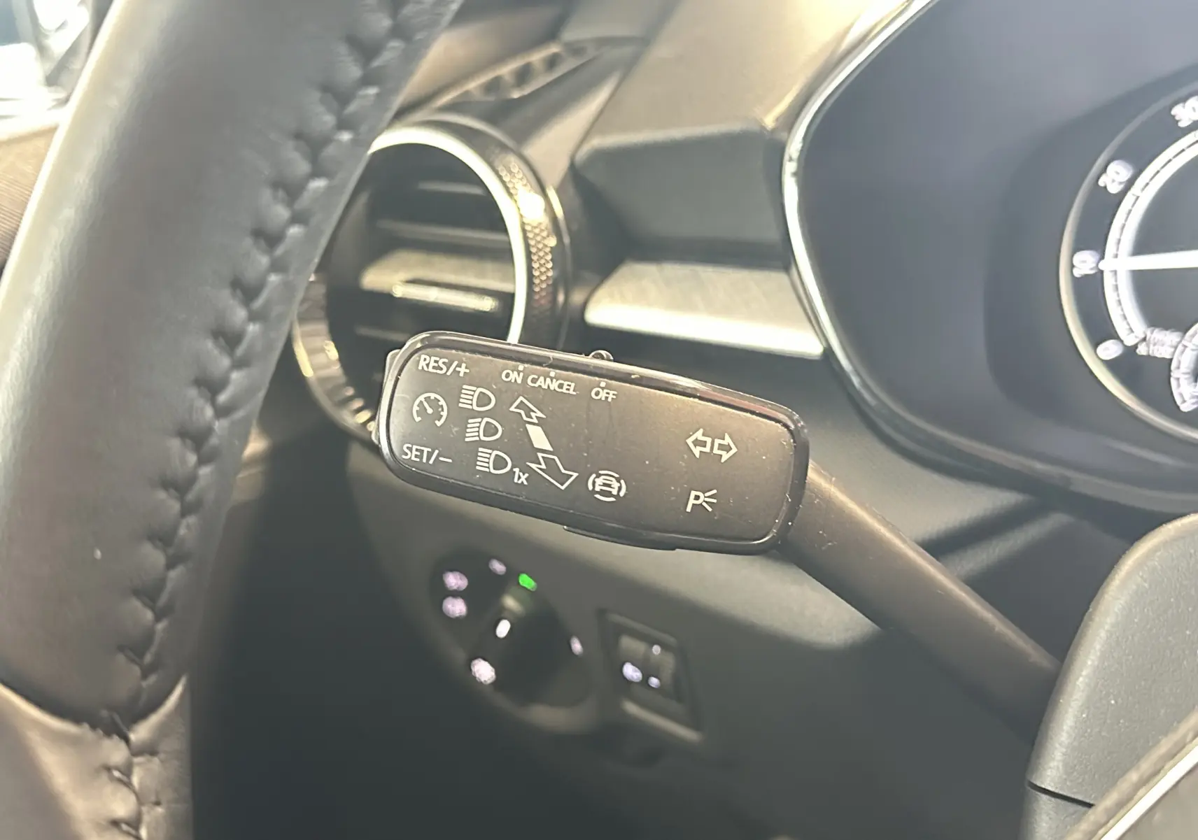 Gros plan sur la commande de régulateur de vitesse à gauche du volant d’une Skoda Fabia gris 2023, intérieur noir.