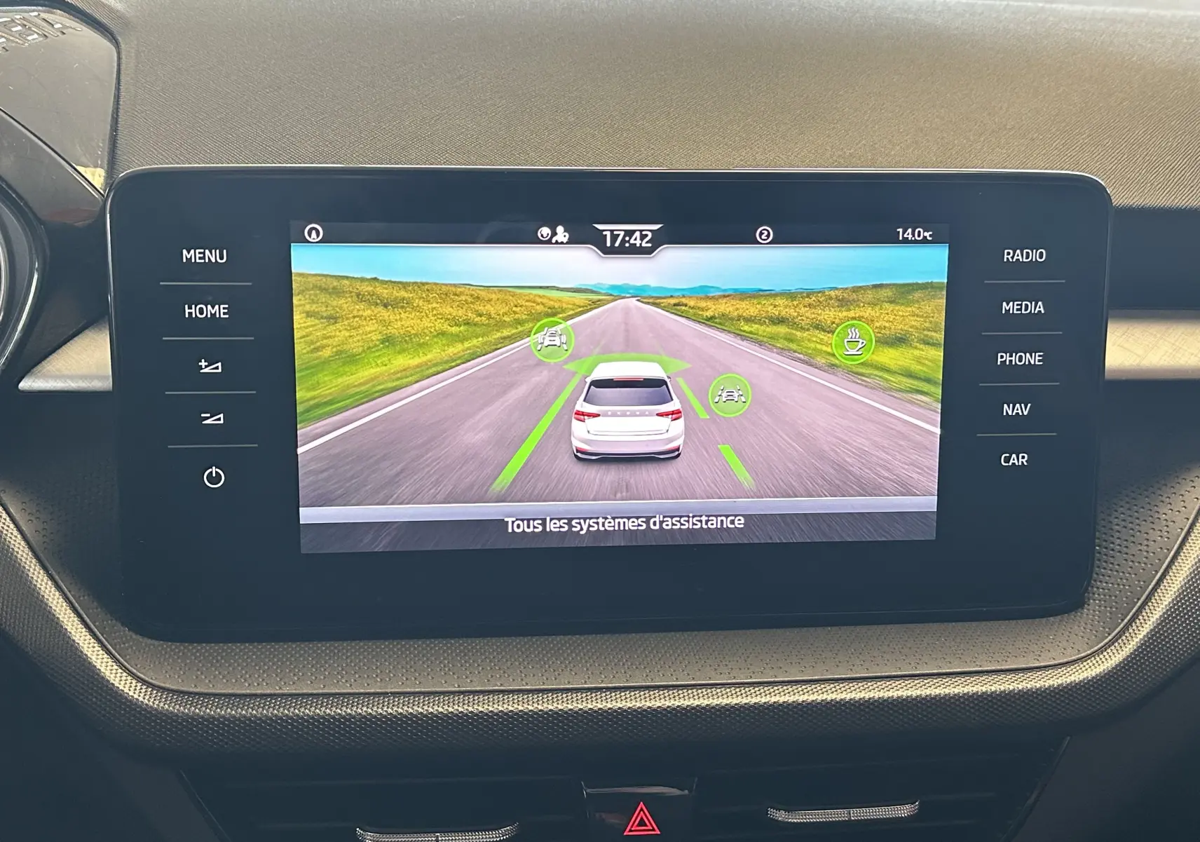 Écran central de la Skoda Fabia Ambition 2023 affichant l'assistance à la conduite avec vue arrière virtuelle du véhicule gris.