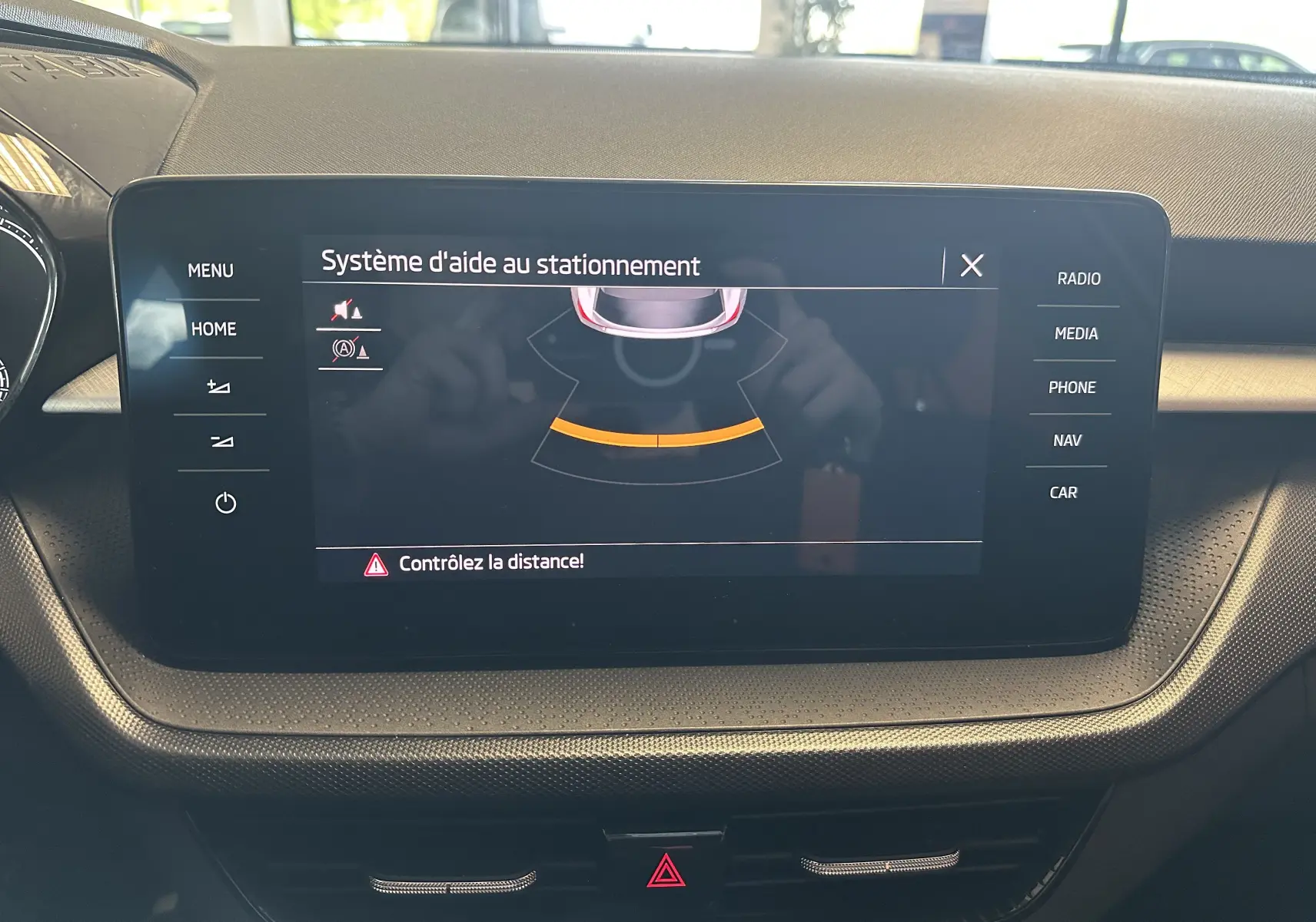Écran central tactile du tableau de bord de la Skoda Fabia Ambition 2023 affichant l'aide au stationnement.
