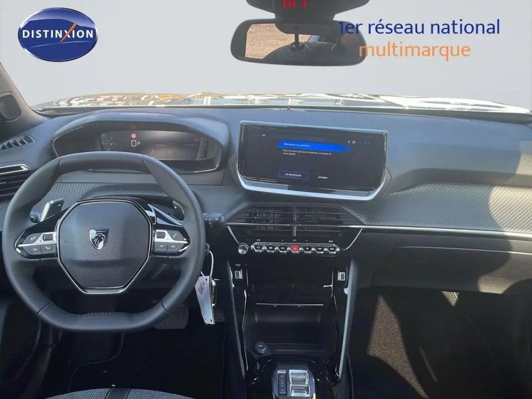 Vue intérieure frontale du tableau de bord gris du Peugeot 2008 1.2 Hybrid 145ch avec écran tactile et volant cuir multifonction.
