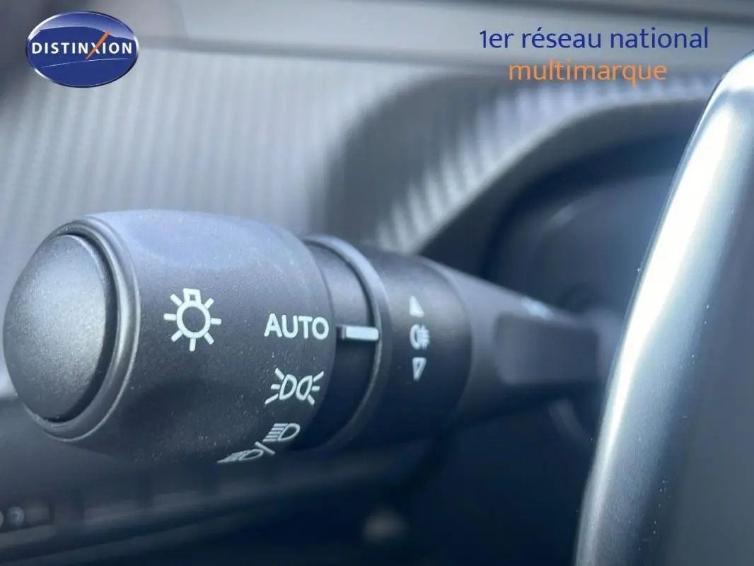 Gros plan sur la commande d’allumage automatique des feux dans l’habitacle du Peugeot 2008 gris hybride 2025.
