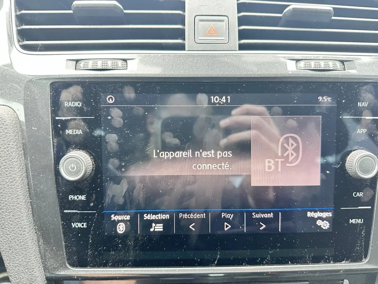 Gros plan sur l'écran tactile central du Volkswagen Golf gris foncé, affichant un message Bluetooth non connecté.
