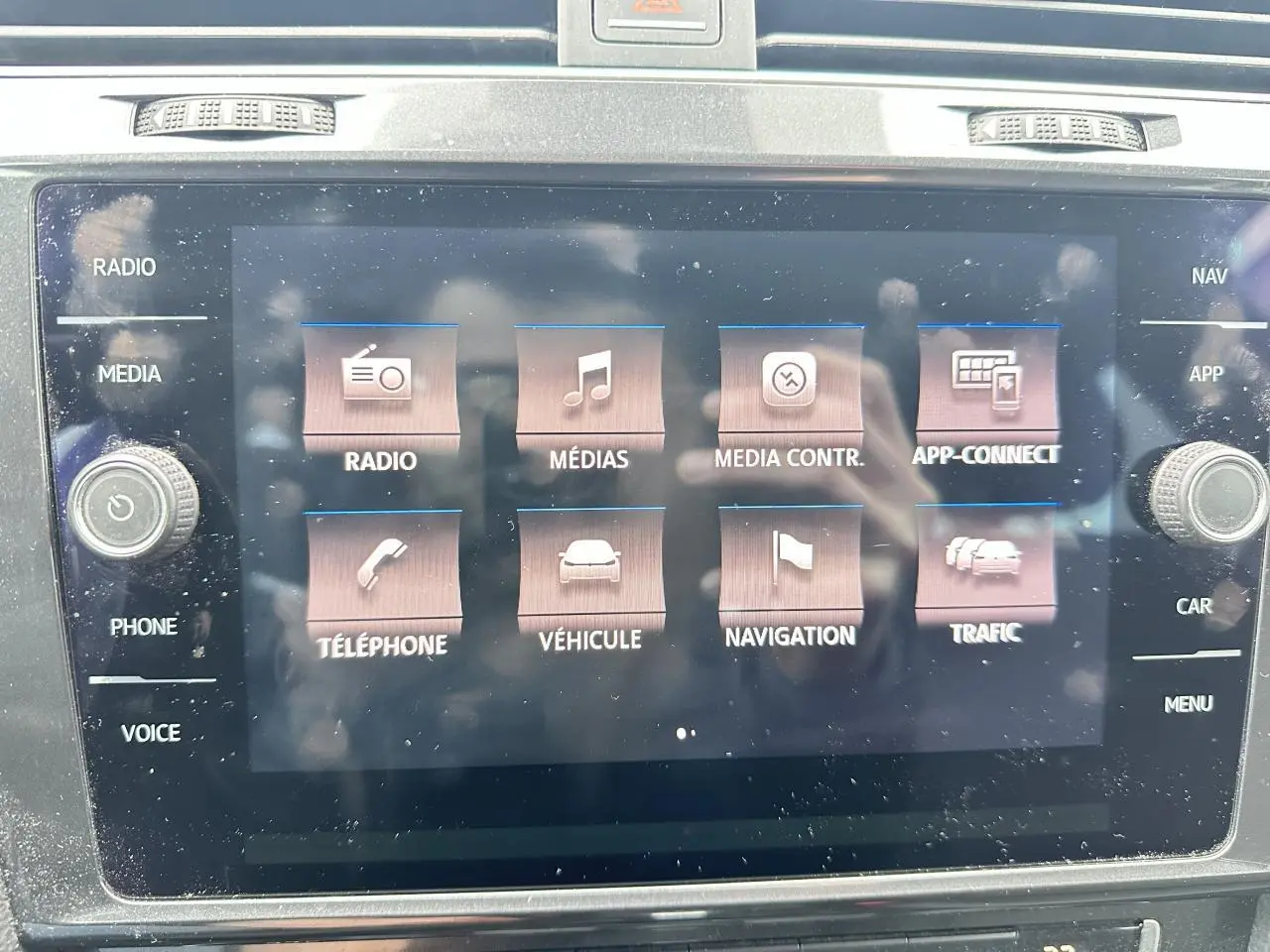 Écran tactile central du système infotainment de la Volkswagen Golf VII, affichant les options multimédia et navigation.
