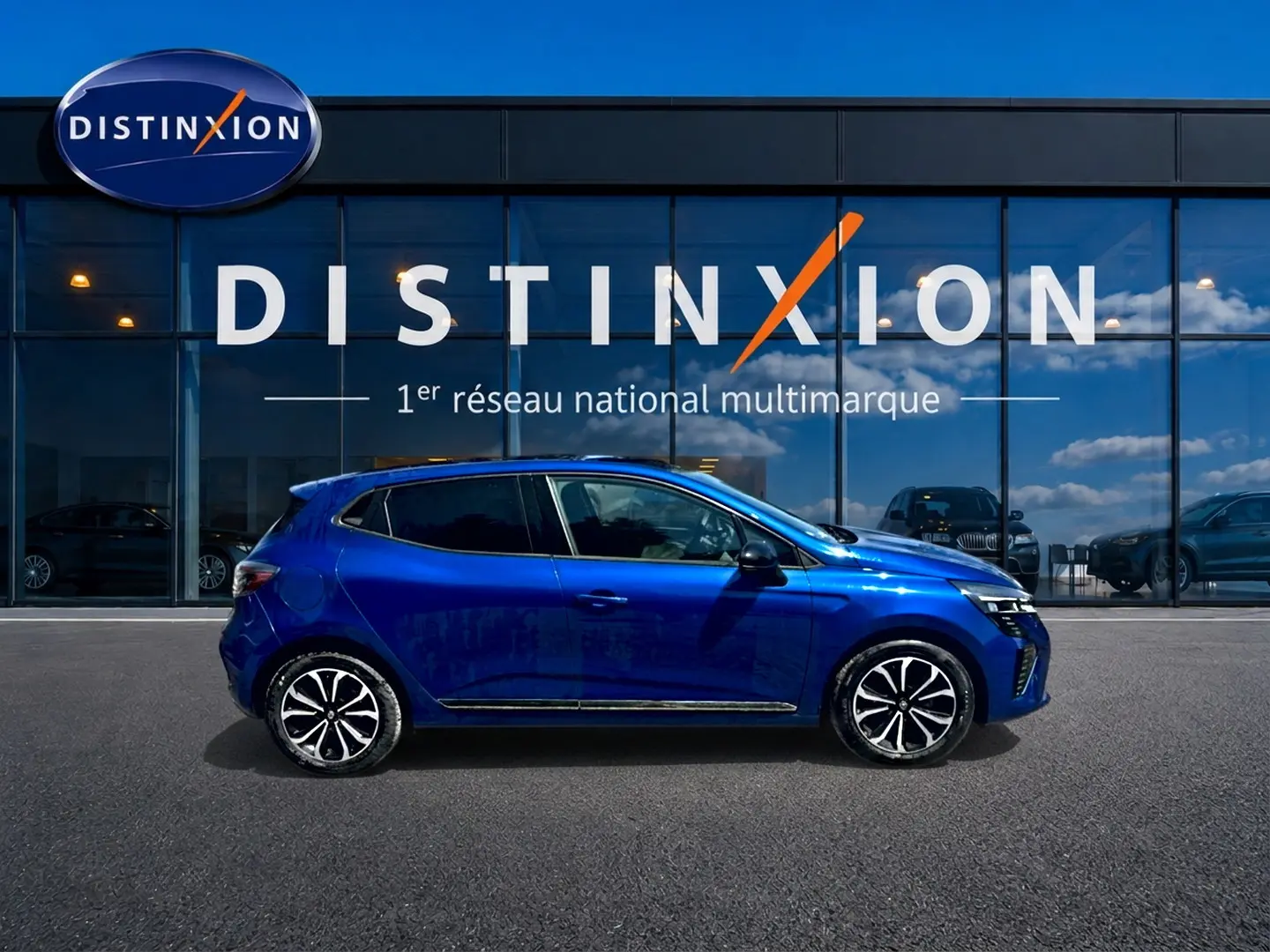 Renault Clio V bleu iron vue de profil côté gauche, avec jantes alu et vitres arrière surteintées.