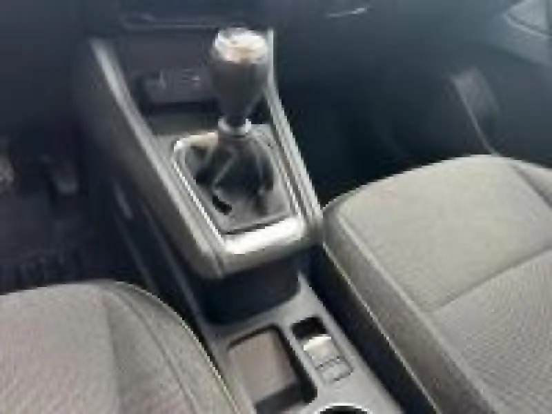Vue intérieure rapprochée du levier de vitesses manuel et des sièges gris du Renault Captur 2025 Techno.