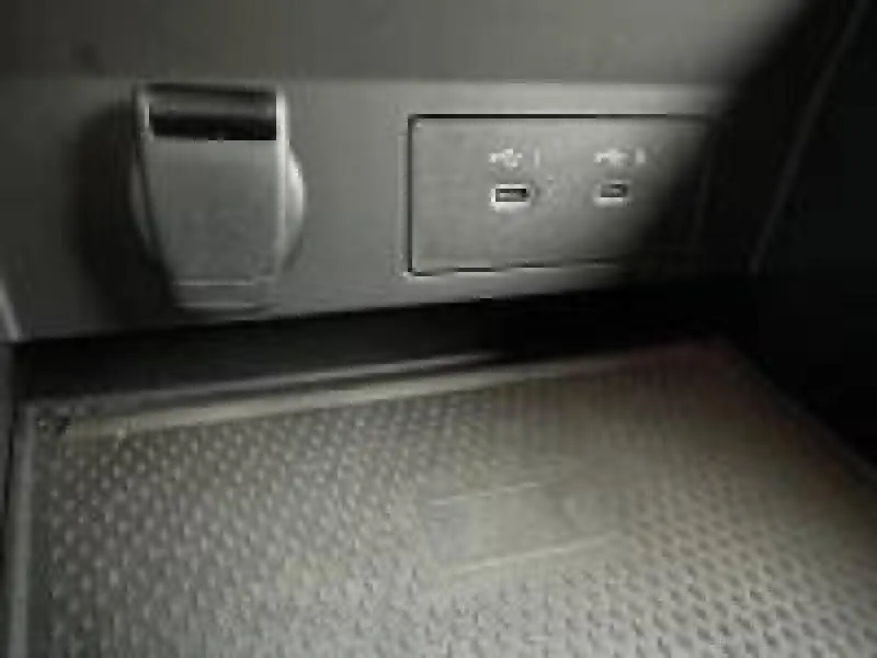 Gros plan sur la prise USB double et la prise 12V dans l'habitacle noir du Renault Captur 2025.
