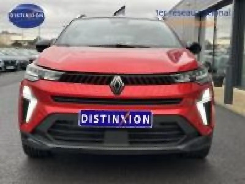 Vue avant d'un Renault Captur rouge flamme nacré 2025 avec feux LED allumés et calandre noire distinctive.