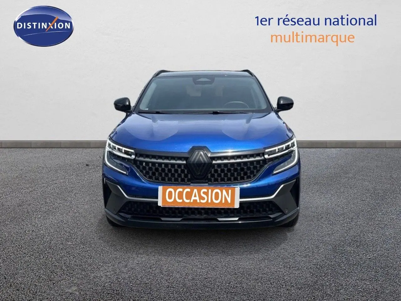 Vue avant d'un Renault Austral 2024 bleu Iron Metal avec toit noir, mettant en valeur sa calandre moderne et ses phares LED.