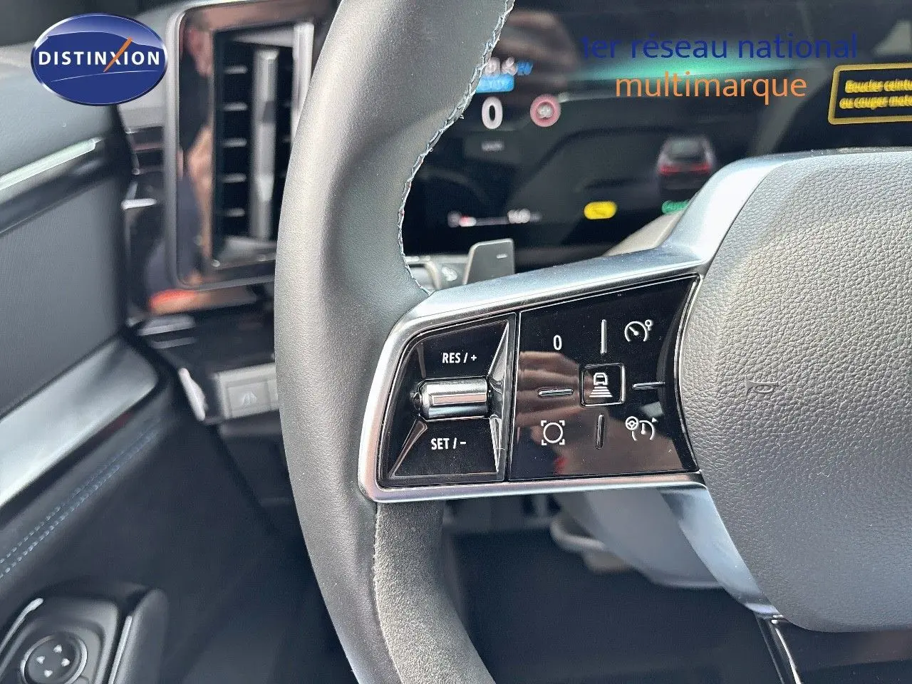 Gros plan sur le volant du Renault Austral 2024 avec commandes de régulateur et tableau de bord numérique en arrière-plan.
