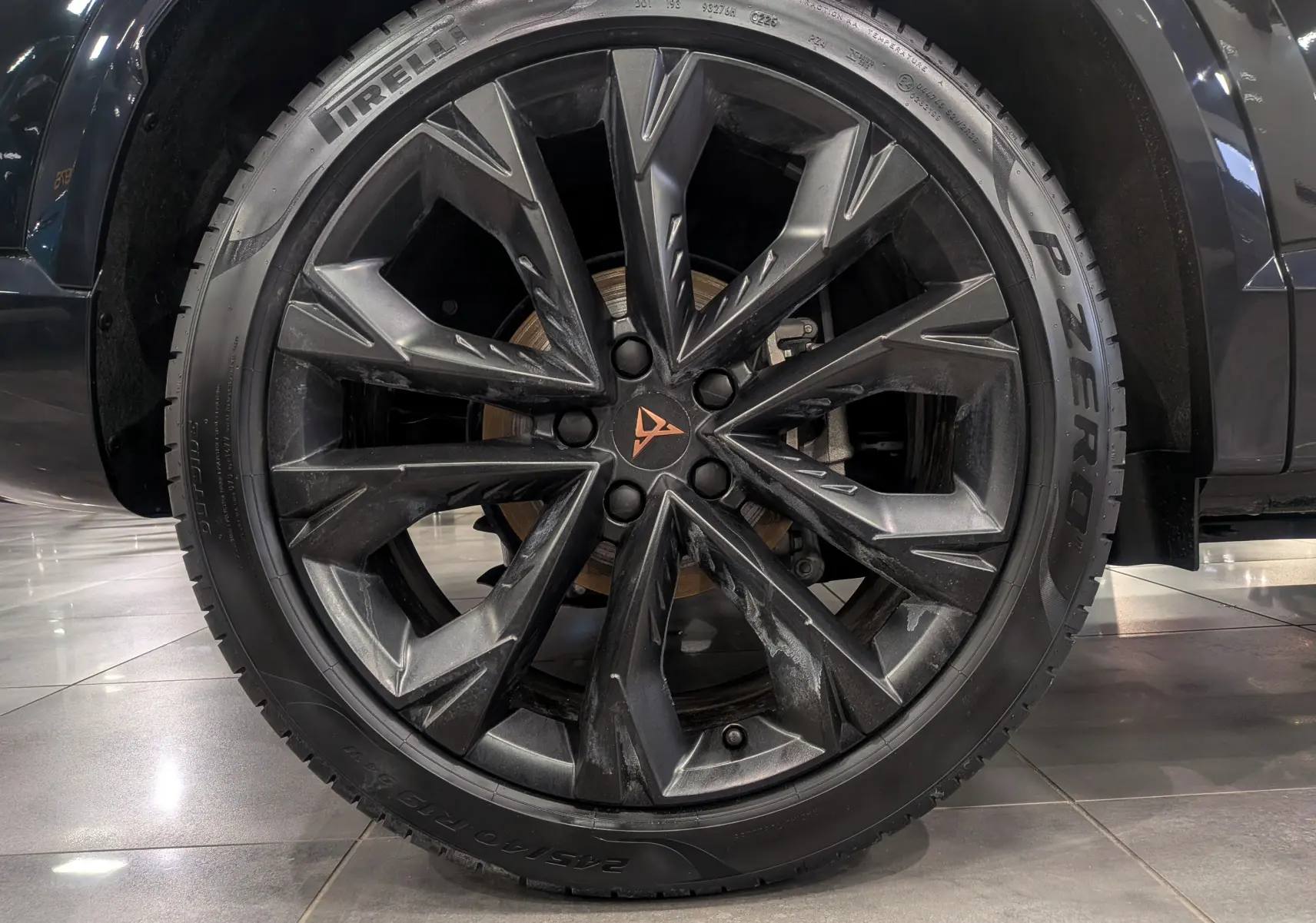 Gros plan sur la jante noire en alliage du CUPRA Formentor eHybrid 2025 avec logo cuivré au centre.