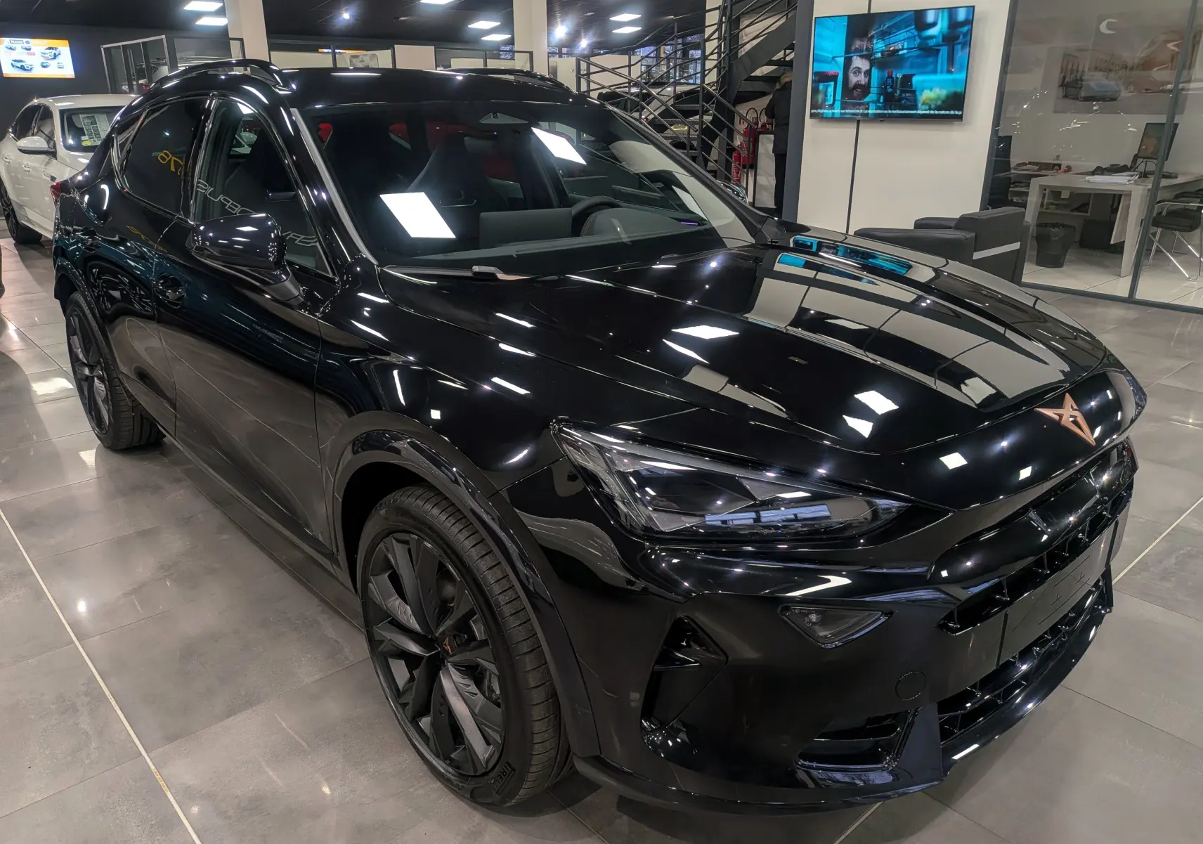 Vue avant d’une CUPRA Formentor eHybrid 2025 en noir minuit, avec logo cuivre distinctif sur le capot lisse.