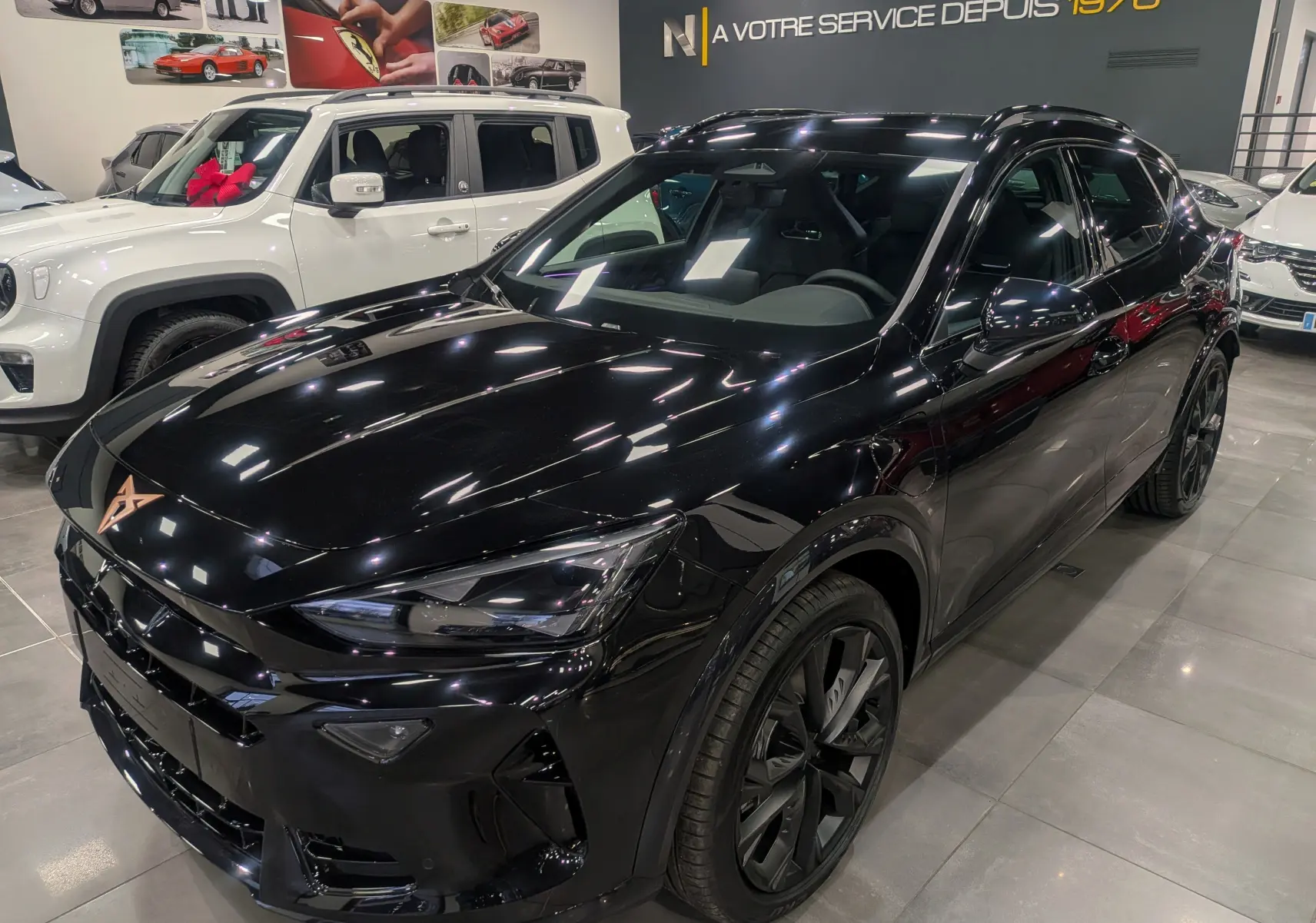 Vue 3/4 avant d'un CUPRA Formentor eHybrid 204 CH noir minuit, avec jantes noires et intérieur visible à travers les vitres teintées.