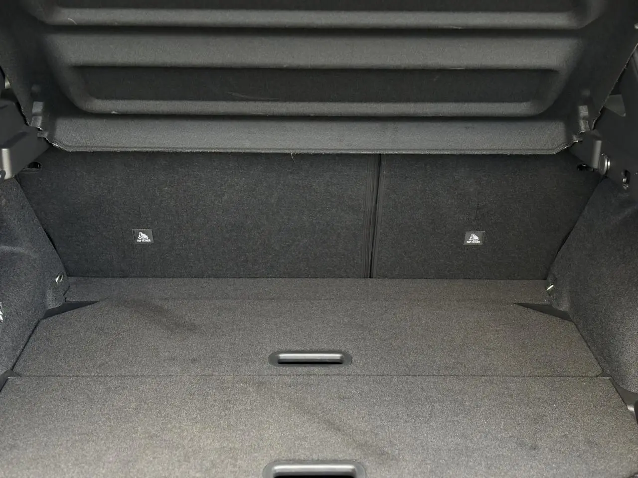 Vue intérieure du coffre ouvert du Nissan Qashqai III gris Ceramic, montrant le plancher modulable et le cache-bagages.