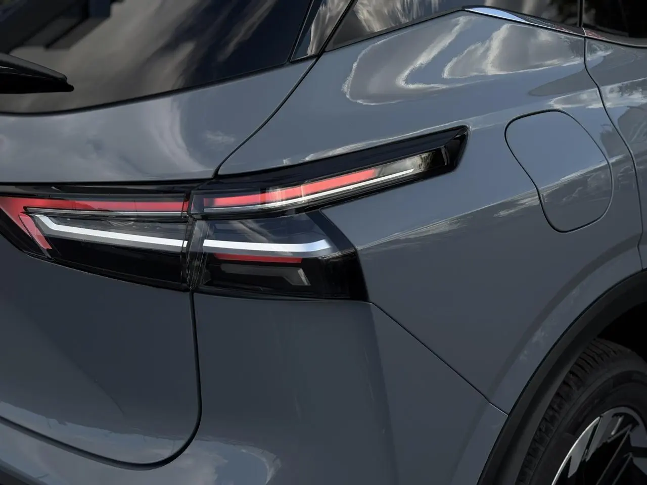 Gros plan sur le feu arrière droit du Nissan Qashqai 2025 gris Ceramic avec hayon électrique et lignes LED distinctives.
