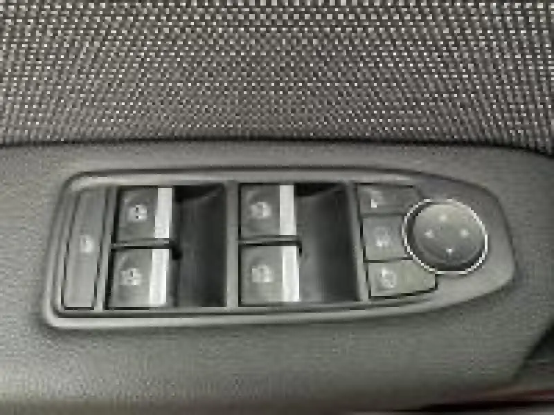 Gros plan sur les commandes de lève-vitres et rétroviseurs côté conducteur du Renault Captur rouge 2025.