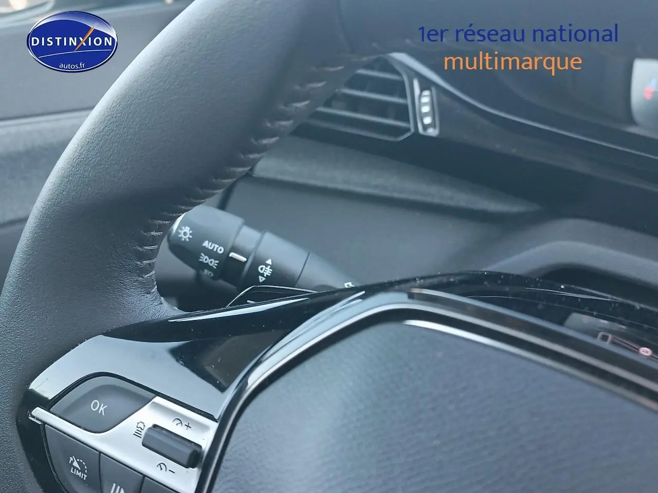 Gros plan sur le volant cuir noir du Peugeot 408 Hybrid 145 allure e-dcs6, avec commandes intégrées visibles.