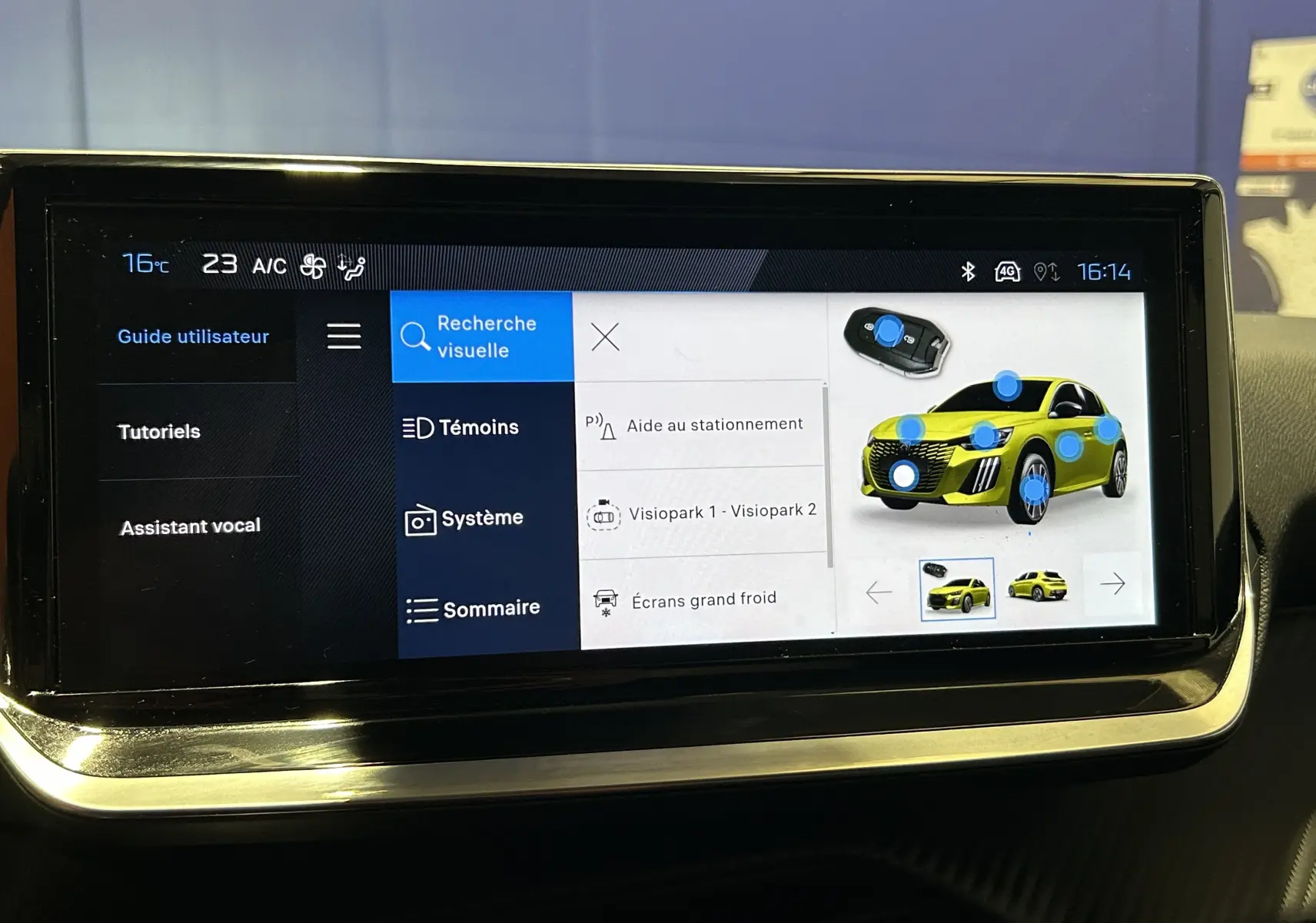Écran tactile intérieur affichant le menu d’aide au stationnement avec illustration d’une Peugeot 208 jaune vue de face.