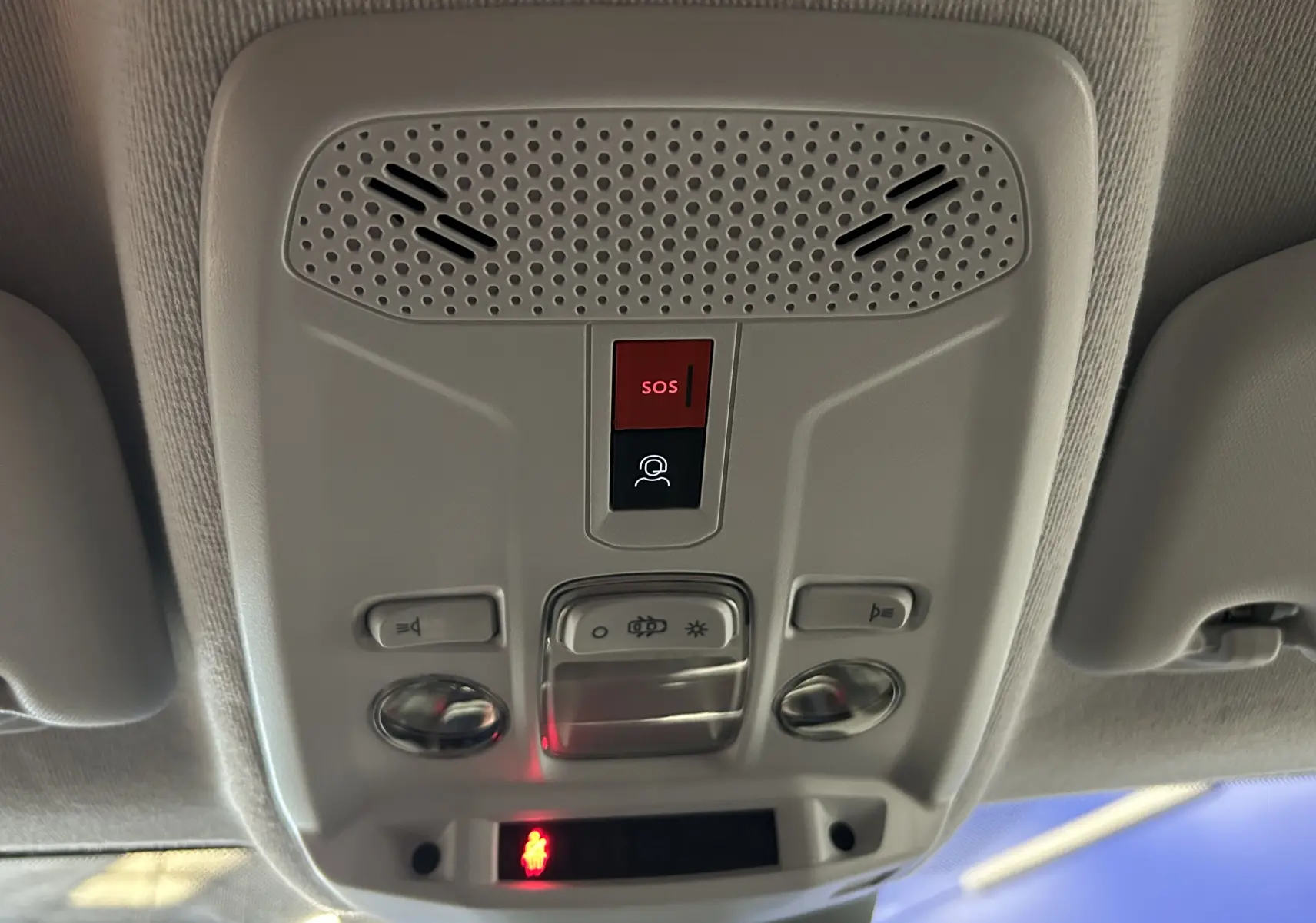 Vue en gros plan du plafonnier intérieur gris avec boutons SOS et éclairage de la Peugeot 208 gris Selenium.