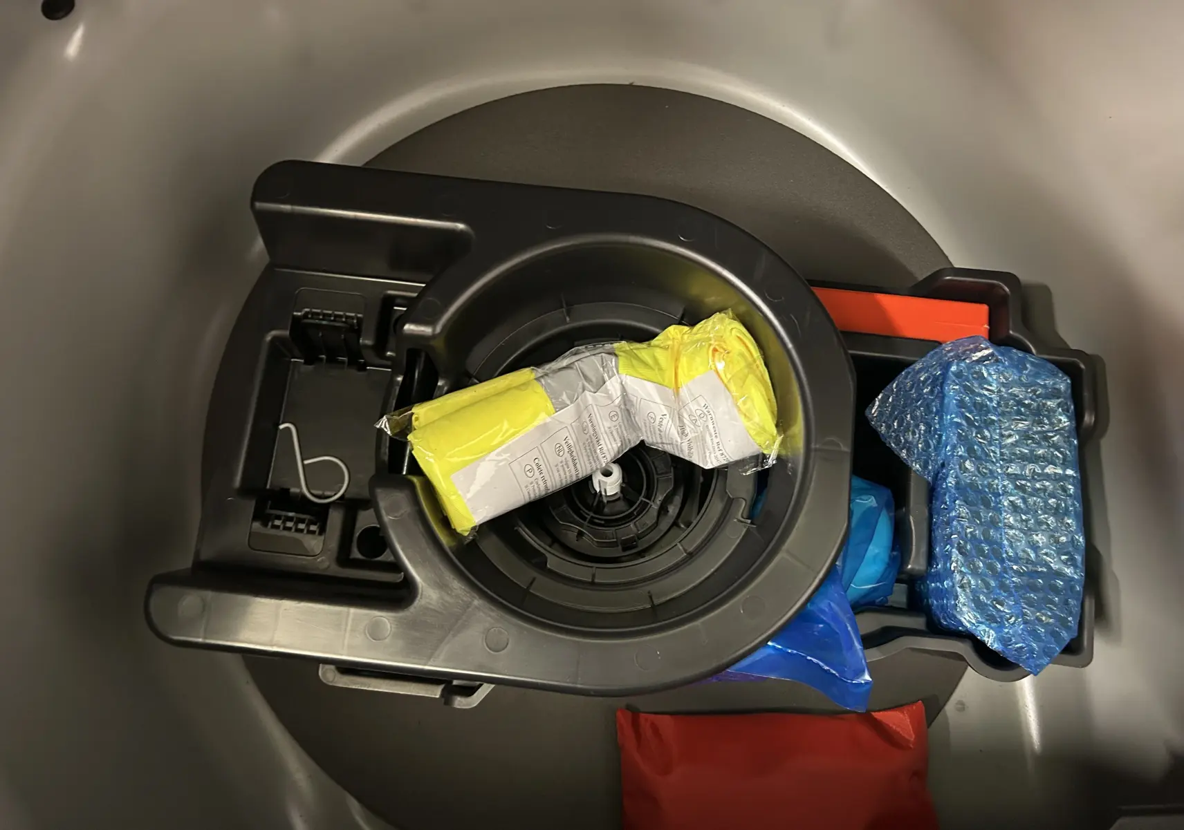 Rangement sous coffre d’une Peugeot 208 gris Selenium, montrant les outils et accessoires d’origine bien rangés.