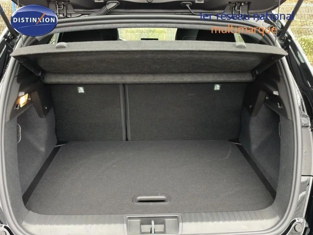 Coffre ouvert vu de l'arrière d'un Renault Captur noir 2025, espace de chargement vide avec cache-bagages relevé.