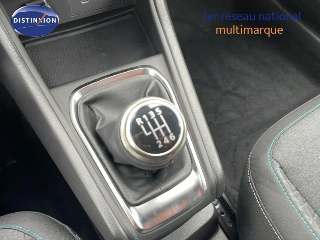 Gros plan sur le levier de vitesses manuel de la Renault Captur noir 2025, avec coutures bleues visibles sur le siège adjacent.