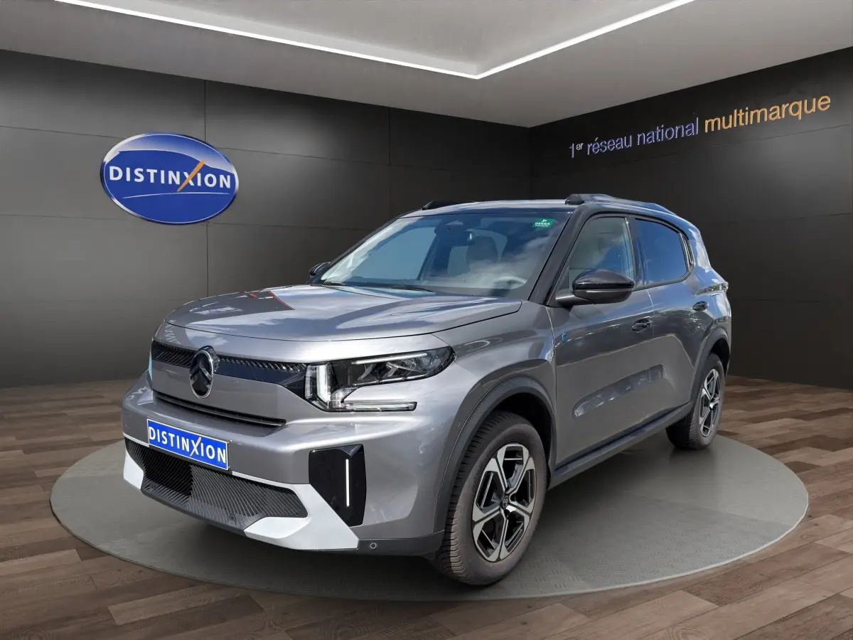 Vue 3/4 avant droite du Citroën C3 Aircross électrique gris foncé avec jantes distinctives et toit noir.