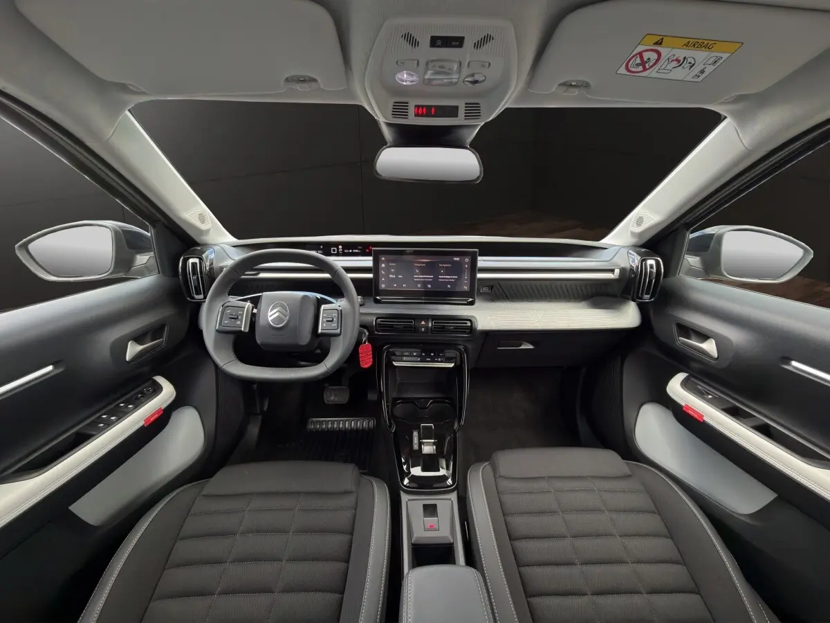 Vue intérieure avant du Citroën C3 Aircross gris foncé, tableau de bord moderne avec écran tactile central et volant multifonctions.
