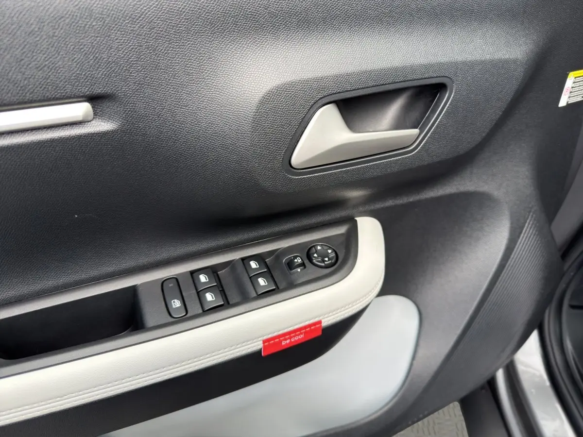 Gros plan sur la porte côté conducteur de la Citroën C3 Aircross gris foncé, avec commandes de vitres et poignée intérieure.