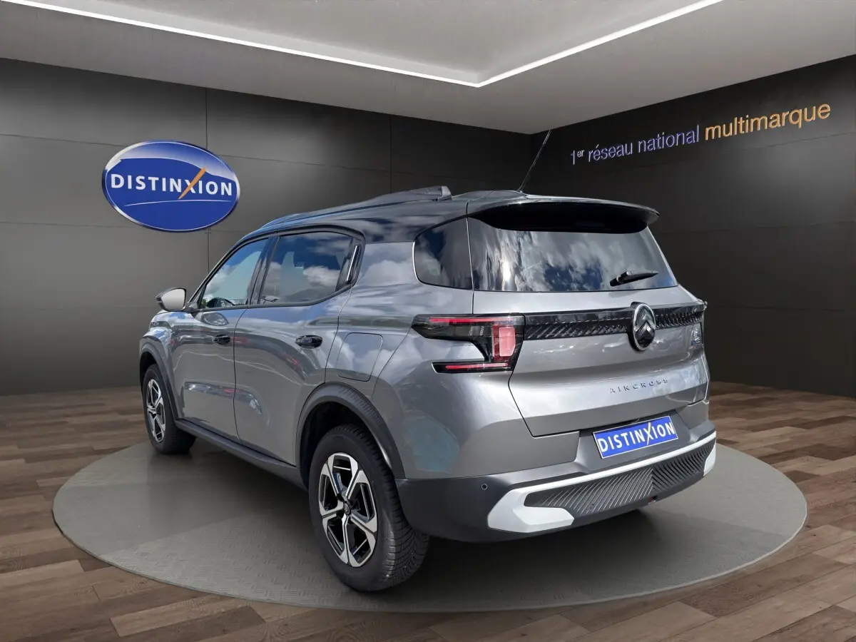 Vue 3/4 arrière droite d’un Citroën C3 Aircross électrique gris foncé avec feux LED et toit noir brillant.