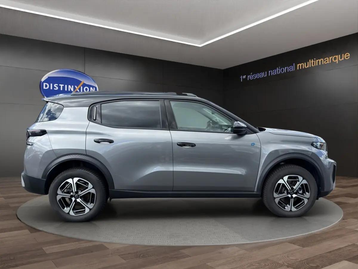 Profil droit du Citroën C3 Aircross électrique gris foncé 2025 avec jantes modernes et barres de toit noires.