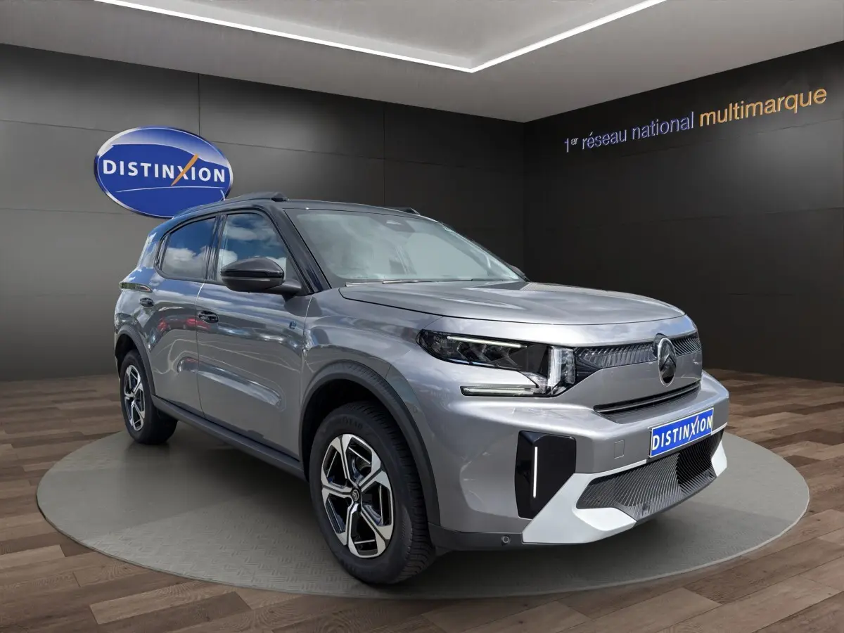 Vue 3/4 avant d'un Citroën C3 Aircross électrique gris foncé avec jantes stylisées et calandre moderne.