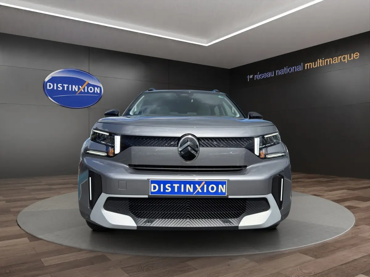 Vue frontale d'un Citroën C3 Aircross électrique gris foncé avec feux LED verticaux et logo distinctif au centre.